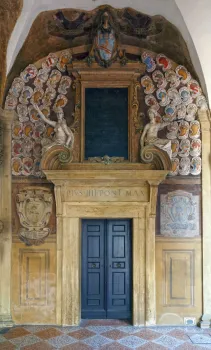 Palast des Archiginnasio, Arkade im Erdgeschoss mit Tür und Wappenreliefs